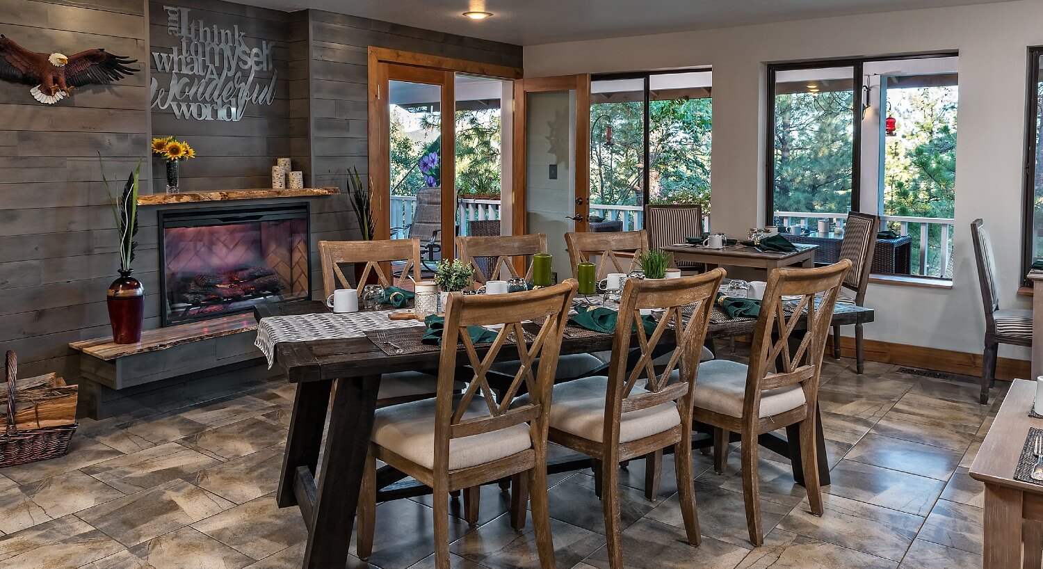 Dining area with rustic fireplace and long wooden dining table with tall back chairs set for six