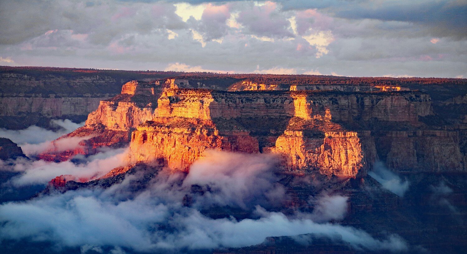 Morning sun shining on a stunning landscape of rock and canyon with low hanging clouds in the valley