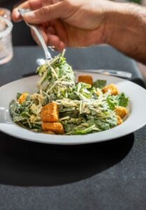 round white bowl with lettuce, croutons & shredded cheese
