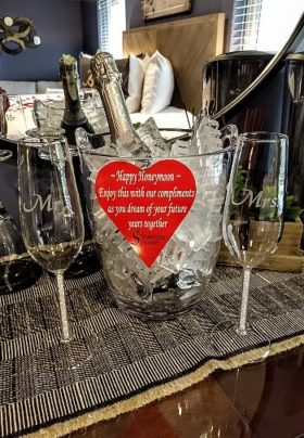 Glass bucket of ice holding a champagne bottle with tall Mr and Mrs champagne glasses