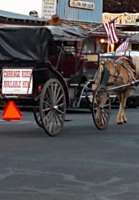 Horsedrawn carriage rolling down street