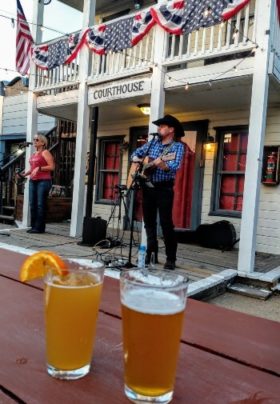 2 beers on table with singers on stage