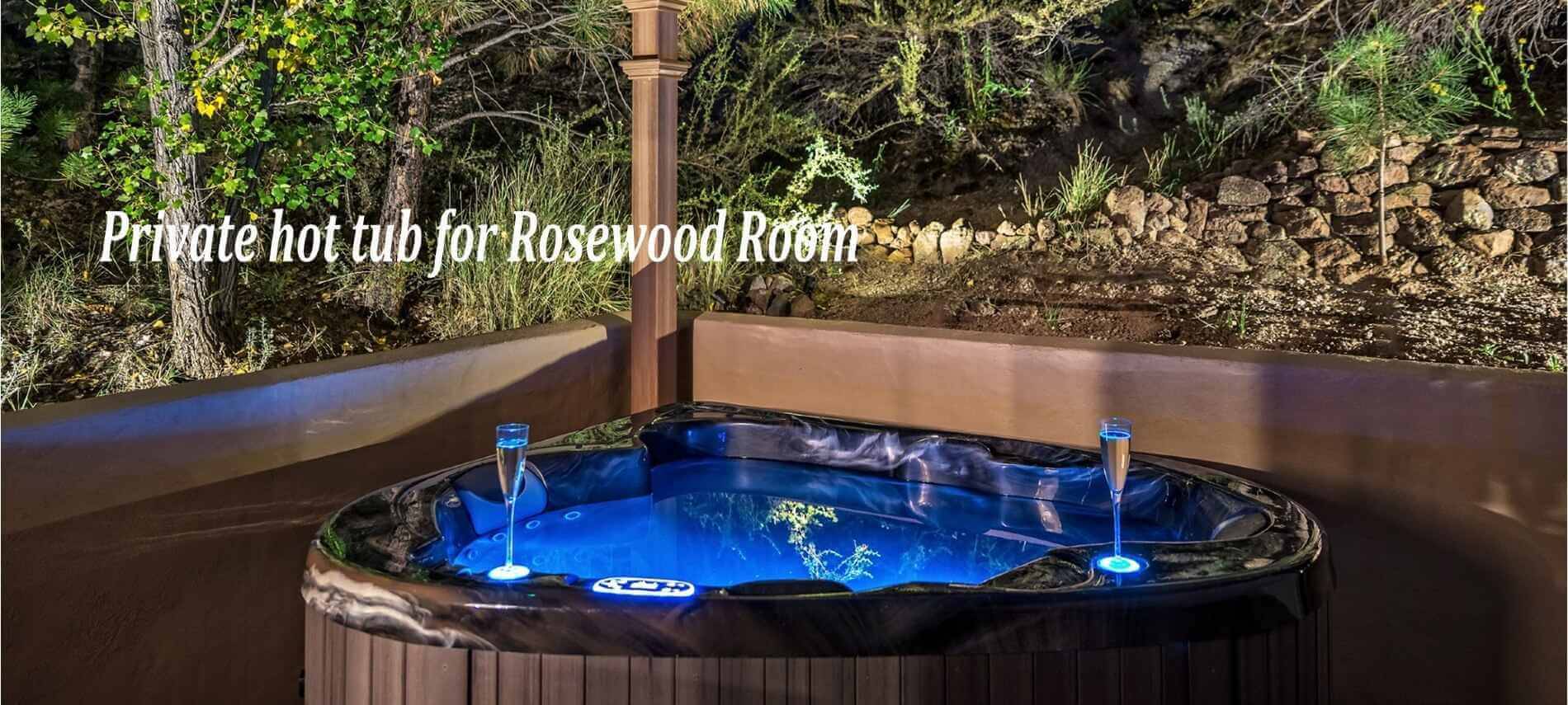 triangle shape hot tub at night with blue lights and 2 champagne glasses outside